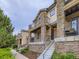 Charming multi-level townhouse with a stone facade, inviting balconies, and professionally landscaped grounds at 3155 E 104Th Ave # 4E, Thornton, CO 80233