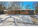 Brick ranch home with updated exterior, snow-covered lawn, and driveway at 725 S Harrison St, Denver, CO 80209