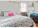 Charming bedroom featuring floral bedding, soft white walls, and bright light at 1315 Xanthia St, Denver, CO 80220