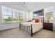 Bright bedroom featuring a wrought iron bed frame, neutral colored bedding, and sun-filled windows at 2027 Vallejo Loop, Broomfield, CO 80023