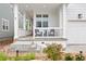 Inviting covered front porch with white railing, chairs, and steps leading to a meticulously landscaped garden at 2027 Vallejo Loop, Broomfield, CO 80023