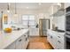 Bright kitchen showcasing white cabinetry, stainless steel appliances, and a stylish backsplash at 2027 Vallejo Loop, Broomfield, CO 80023