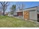 Backyard featuring a shed with barn door, brick house, and grassy lawn, perfect for outdoor activities at 32 Skyline Dr, Wheat Ridge, CO 80215