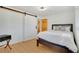 Bright bedroom features wood floors, barn door closet, and adjacent bathroom at 32 Skyline Dr, Wheat Ridge, CO 80215