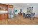 Open-concept dining area featuring hardwood floors, a dining table, and stainless steel refrigerator at 32 Skyline Dr, Wheat Ridge, CO 80215