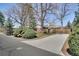 Quaint home featuring mature landscaping and a concrete driveway leading to a well-maintained yard at 32 Skyline Dr, Wheat Ridge, CO 80215