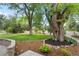 Beautiful front yard featuring a lush green lawn and large, mature trees at 32 Skyline Dr, Wheat Ridge, CO 80215
