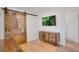 Living room boasts hardwood floors, stylish wooden cabinet, a flat-screen tv and a rusted barn door at 32 Skyline Dr, Wheat Ridge, CO 80215