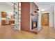 Open-concept with brick fireplace and hardwood floors connecting living room to kitchen at 32 Skyline Dr, Wheat Ridge, CO 80215