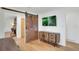 Living room boasts hardwood floors, stylish wooden cabinet, a flat-screen tv and a rusted barn door at 32 Skyline Dr, Wheat Ridge, CO 80215
