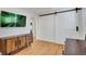 Living room boasts hardwood floors, stylish wooden cabinet, a flat-screen tv and a white barn door at 32 Skyline Dr, Wheat Ridge, CO 80215