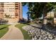 Picturesque walkway through a beautifully landscaped courtyard area with lush green lawn and mature trees at 100 Park W Ave # 1403, Denver, CO 80205