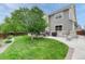Well-maintained backyard with a lush lawn, mature tree, patio and access to the second story deck at 5625 S Buchanan St, Aurora, CO 80016