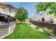 Backyard with a patio umbrella and shed, surrounded by a wooden fence, grass and rock landscaping at 5625 S Buchanan St, Aurora, CO 80016