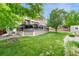 Beautiful backyard featuring a spacious deck with furniture and a well-manicured lawn at 5625 S Buchanan St, Aurora, CO 80016