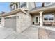 Close-up of the home's exterior showcasing the front entrance, brick accents, and attached two car garage at 5625 S Buchanan St, Aurora, CO 80016
