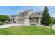 Charming two-story home featuring a landscaped front yard, brick accents, and attached two car garage at 5625 S Buchanan St, Aurora, CO 80016