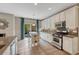 Bright kitchen features white cabinets, stainless steel appliances, and center island, with deck access at 5625 S Buchanan St, Aurora, CO 80016