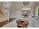 Open-concept living room with a view of the staircase, featuring neutral tones and bright natural lighting at 5625 S Buchanan St, Aurora, CO 80016