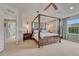 Main bedroom with canopy bed frame, ceiling fan, large windows, and en-suite bath access at 5625 S Buchanan St, Aurora, CO 80016