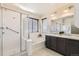 Bathroom featuring shower with glass door, soaking tub, and dual sinks at 8562 E 49Th Pl, Denver, CO 80238