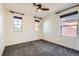 Empty bedroom features neutral paint, carpet, and three windows with black hardware at 8562 E 49Th Pl, Denver, CO 80238