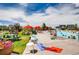 Large community pool area with lounge chairs, umbrellas, picnic tables, and well-maintained landscaping at 8562 E 49Th Pl, Denver, CO 80238