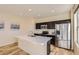 Modern kitchen featuring stainless steel appliances, a breakfast bar, and sleek dark cabinetry at 8562 E 49Th Pl, Denver, CO 80238