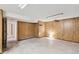 Unfinished basement with concrete flooring and wood paneling, offering potential for customization and additional living space at 14333 E Warren Pl, Aurora, CO 80014