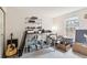 Bedroom with large window, filled with personal belongings, a guitar, and shelving, offering functional space at 14333 E Warren Pl, Aurora, CO 80014
