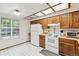 Bright kitchen features white appliances, wood cabinets, and a charming breakfast nook at 14333 E Warren Pl, Aurora, CO 80014