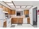 Traditional kitchen featuring wood cabinets, white appliances, and patterned flooring, creating a warm, inviting atmosphere at 14333 E Warren Pl, Aurora, CO 80014