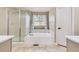 Bright bathroom featuring a large tub with shower head and tiled floors at 3416 Hawthorne Dr, Highlands Ranch, CO 80126