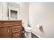 Bathroom featuring wood vanity, toilet, and large mirror at 3416 Hawthorne Dr, Highlands Ranch, CO 80126