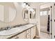 Bright bathroom boasting dual sinks with granite countertops and oval mirrors at 3416 Hawthorne Dr, Highlands Ranch, CO 80126