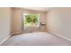 Bright, carpeted bedroom with a large window overlooking the landscaped yard at 3416 Hawthorne Dr, Highlands Ranch, CO 80126