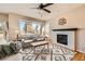 Bright living room featuring a fireplace, large windows offering neighborhood views, and stylish decor at 3416 Hawthorne Dr, Highlands Ranch, CO 80126