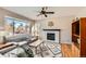 Cozy living room with a fireplace, large windows, ceiling fan, and modern decor at 3416 Hawthorne Dr, Highlands Ranch, CO 80126