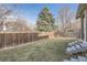 Backyard with wood fence, steps to the deck, and a mature evergreen tree at 4234 S Bahama St, Aurora, CO 80013