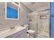 Well-lit bathroom featuring marble wall tiles, a glass-enclosed shower, and a white vanity with chrome fixtures at 4234 S Bahama St, Aurora, CO 80013