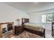 Comfortable bedroom featuring a queen-sized bed, a wooden nightstand, an area rug, and ample natural light from the window at 4234 S Bahama St, Aurora, CO 80013