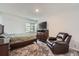 Cozy bedroom with a queen bed, a dresser with a TV, and a comfortable leather recliner near the window at 4234 S Bahama St, Aurora, CO 80013