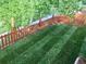 An overhead view of a meticulously striped lawn enclosed by a red fence, suggesting a well-maintained backyard space at 15972 W 70Th Dr, Arvada, CO 80007