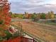 A serene backyard view showcasing vibrant fall foliage, a well-maintained path, and a sense of peaceful outdoor living at 15972 W 70Th Dr, Arvada, CO 80007