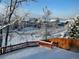 Snowy backyard view with wooden fence and houses in distance at 15972 W 70Th Dr, Arvada, CO 80007