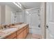 Bathroom featuring double sinks, granite counters, and a shower-tub combo at 15972 W 70Th Dr, Arvada, CO 80007