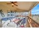 Large covered deck with seating, ceiling fan, and wood railing at 15972 W 70Th Dr, Arvada, CO 80007