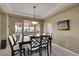 Elegant dining room with a large table, chair set, tray ceiling, and natural light at 15972 W 70Th Dr, Arvada, CO 80007