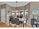 Bright dining room features a pendant light, wood floors, and views of the outdoor deck at 15972 W 70Th Dr, Arvada, CO 80007