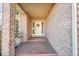 Inviting front porch featuring brick detailing, a welcoming wreath, and covered entry at 15972 W 70Th Dr, Arvada, CO 80007